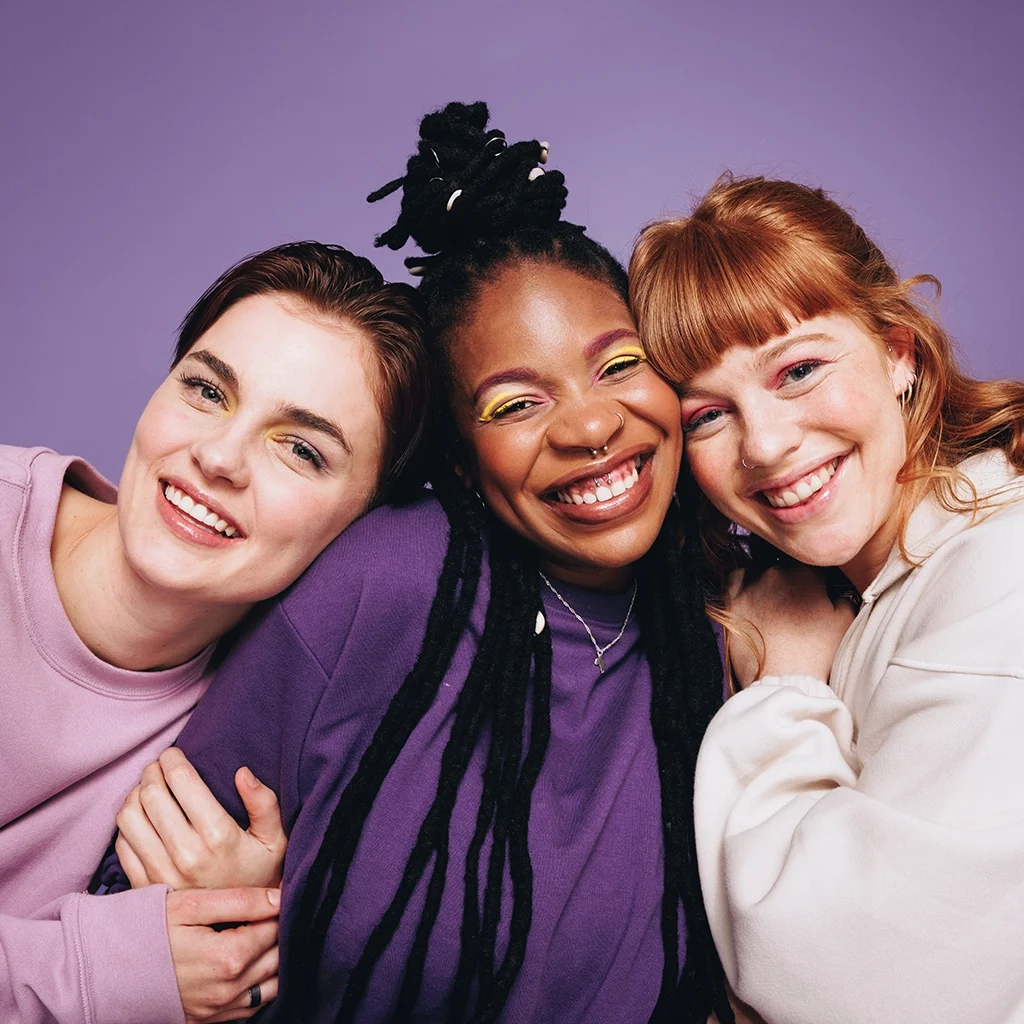 portrait of smiling happy female friends in purple theme